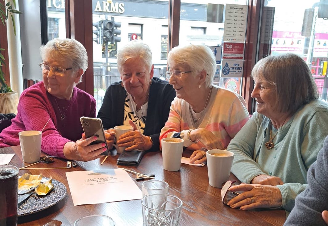 four ladies looking at an iPhone